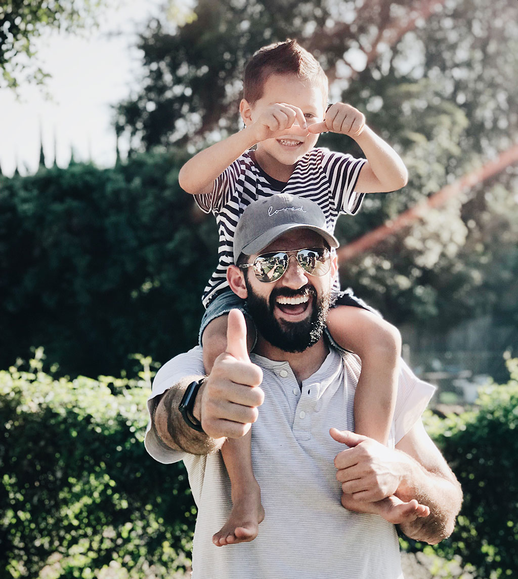 Man with beard with young boy on his shoulders