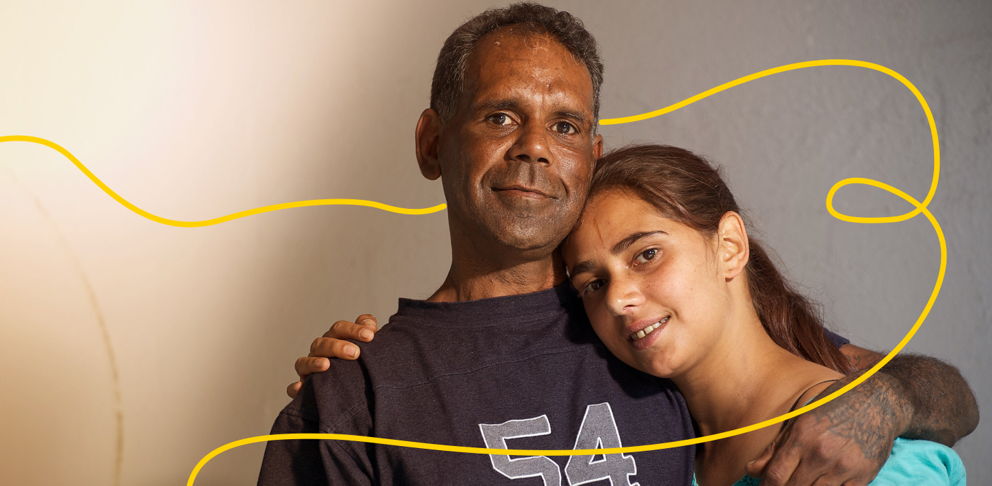 Indigenous Australian man with his adult daughter against a grey background